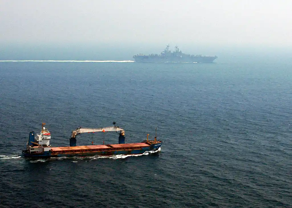 us navy 040705 n 2972r 040 a merchant ship sails off the starboard side of the amphibious assault ship uss kearsarge (lhd 3) while transiting the straits of hormuz