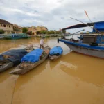 channels of hoi an ancient town with traditional wooden fishing vessels