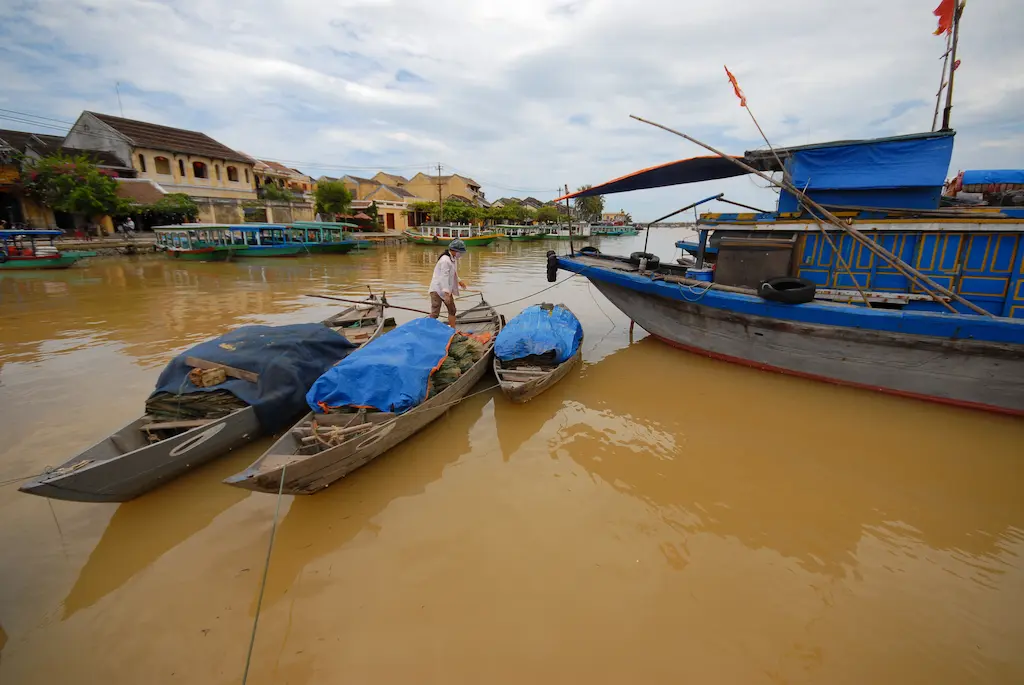 channels of hoi an ancient town with traditional wooden fishing vessels