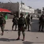 israeli soldiers blocking street in hebron